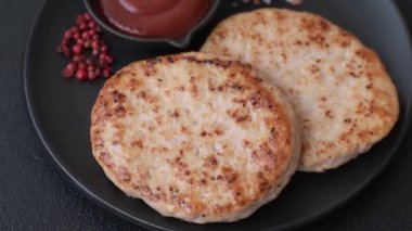 Koyu beton zeminde tuzlu, baharatlı ve otlu ızgara tavuk burgeri.