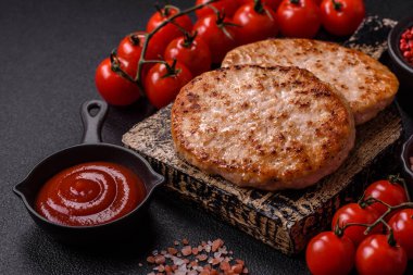 Koyu beton zeminde tuzlu, baharatlı ve otlu ızgara tavuk burgeri.