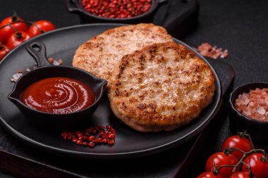 Koyu beton zeminde tuzlu, baharatlı ve otlu ızgara tavuk burgeri.