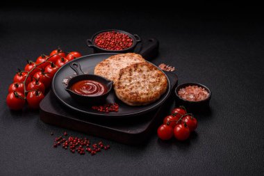 Koyu beton zeminde tuzlu, baharatlı ve otlu ızgara tavuk burgeri.