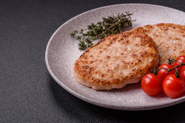 Koyu beton zeminde tuzlu, baharatlı ve otlu ızgara tavuk burgeri.