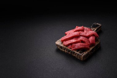 Evde yemek pişirmek için tuz ve baharatla dilimlenmiş lezzetli çiğ et.