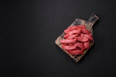 Evde yemek pişirmek için tuz ve baharatla dilimlenmiş lezzetli çiğ et.