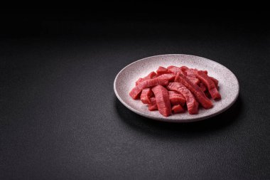 Evde yemek pişirmek için tuz ve baharatla dilimlenmiş lezzetli çiğ et.