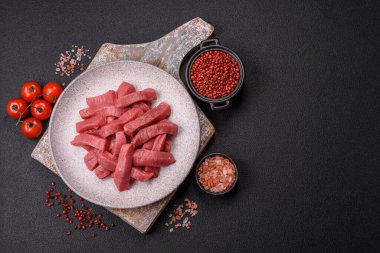 Evde yemek pişirmek için tuz ve baharatla dilimlenmiş lezzetli çiğ et.