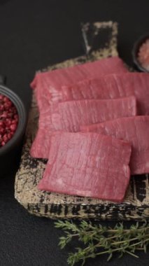 Evde yemek pişirmek için tuz ve baharatla dilimlenmiş lezzetli çiğ et.