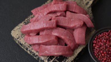 Evde yemek pişirmek için tuz ve baharatla dilimlenmiş lezzetli çiğ et.