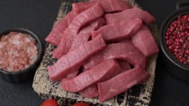 Evde yemek pişirmek için tuz ve baharatla dilimlenmiş lezzetli çiğ et.