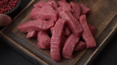 Evde yemek pişirmek için tuz ve baharatla dilimlenmiş lezzetli çiğ et.