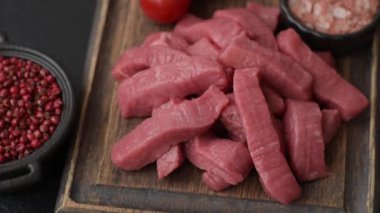 Evde yemek pişirmek için tuz ve baharatla dilimlenmiş lezzetli çiğ et.