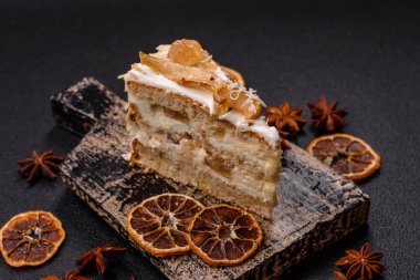 Krema, armut ve dorblu peynirli, koyu beton arkaplanda katmanlı tatlı pasta.