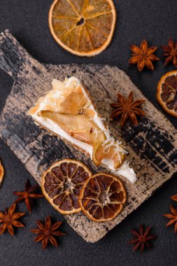 Krema, armut ve dorblu peynirli, koyu beton arkaplanda katmanlı tatlı pasta.