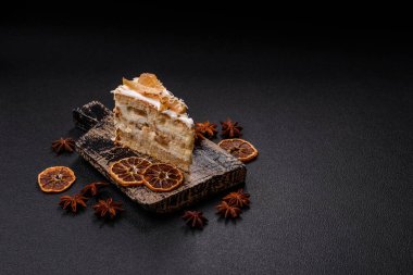 Krema, armut ve dorblu peynirli, koyu beton arkaplanda katmanlı tatlı pasta.