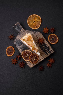 Krema, armut ve dorblu peynirli, koyu beton arkaplanda katmanlı tatlı pasta.