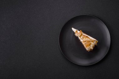 Krema, armut ve dorblu peynirli, koyu beton arkaplanda katmanlı tatlı pasta.