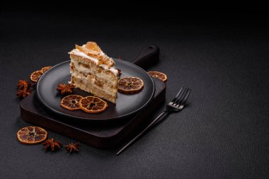 Krema, armut ve dorblu peynirli, koyu beton arkaplanda katmanlı tatlı pasta.