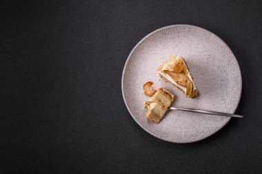 Krema, armut ve dorblu peynirli, koyu beton arkaplanda katmanlı tatlı pasta.