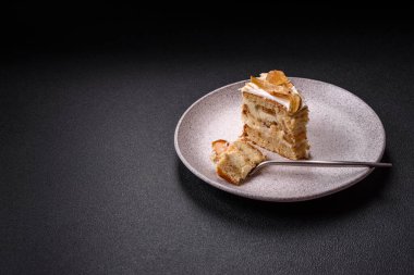 Krema, armut ve dorblu peynirli, koyu beton arkaplanda katmanlı tatlı pasta.