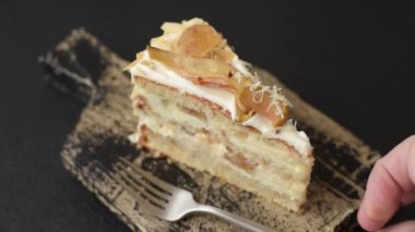 Krema, armut ve dorblu peynirli, koyu beton arkaplanda katmanlı tatlı pasta.