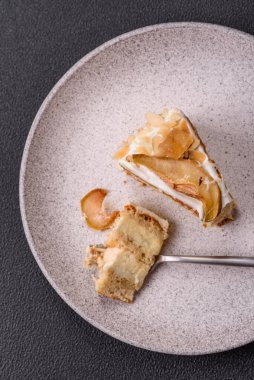 Krema, armut ve dorblu peynirli, koyu beton arkaplanda katmanlı tatlı pasta.