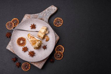 Krema, armut ve dorblu peynirli, koyu beton arkaplanda katmanlı tatlı pasta.