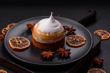 Kremalı tatlı limonlu tart ve koyu beton arka planda lezzet.