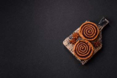 Baharatlı taze tarçınlı rulo ve siyah arka planda kakao. Cinnabon çörekleri. İsveç kahvaltısı.