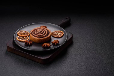 Baharatlı taze tarçınlı rulo ve siyah arka planda kakao. Cinnabon çörekleri. İsveç kahvaltısı.