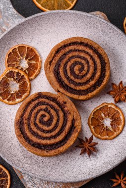 Baharatlı taze tarçınlı rulo ve siyah arka planda kakao. Cinnabon çörekleri. İsveç kahvaltısı.