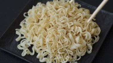 Pirinç eriştesi, soya soslu Asya yemeği ve koyu beton arka planda baharatlar.