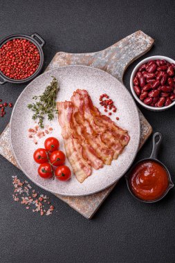 Pastırma dilimlenmiş, tuzlu ve baharatlı, koyu beton bir arka planda.