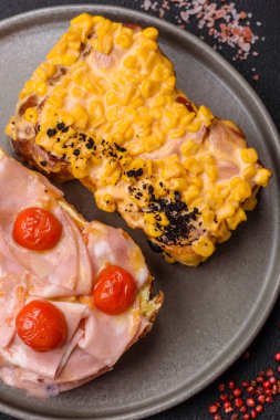 Brioche, et, erimiş peynir, jambon, domates, tuz, baharat ve otlu sandviç.