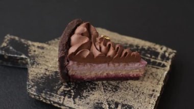 Çilek aromalı mascarpone peynirli bir parça tatlı cheesecake. Koyu beton arka planda çikolata ile kaplanmış.