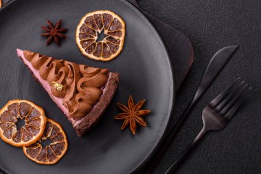 Çilek aromalı mascarpone peynirli bir parça tatlı cheesecake. Koyu beton arka planda çikolata ile kaplanmış.