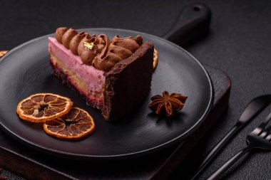 Çilek aromalı mascarpone peynirli bir parça tatlı cheesecake. Koyu beton arka planda çikolata ile kaplanmış.