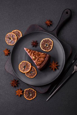 Çilek aromalı mascarpone peynirli bir parça tatlı cheesecake. Koyu beton arka planda çikolata ile kaplanmış.