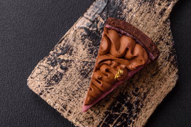 Çilek aromalı mascarpone peynirli bir parça tatlı cheesecake. Koyu beton arka planda çikolata ile kaplanmış.