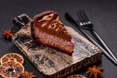 Çilek aromalı mascarpone peynirli bir parça tatlı cheesecake. Koyu beton arka planda çikolata ile kaplanmış.