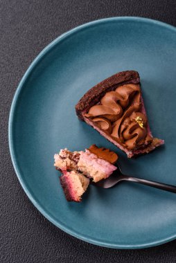 Çilek aromalı mascarpone peynirli bir parça tatlı cheesecake. Koyu beton arka planda çikolata ile kaplanmış.