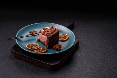 Çilek aromalı mascarpone peynirli bir parça tatlı cheesecake. Koyu beton arka planda çikolata ile kaplanmış.