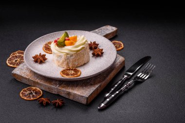 Turunçgil, kivi ve nar tohumlu, koyu beton arkaplanda bir parça tatlı krema.