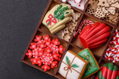 Lezzetli zencefilli çörek, madeleine bisküvileri ve koyu beton arka planda diğer Noel süsleri.