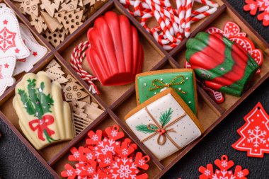 Lezzetli zencefilli çörek, madeleine bisküvileri ve koyu beton arka planda diğer Noel süsleri.