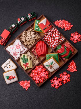 Lezzetli zencefilli çörek, madeleine bisküvileri ve koyu beton arka planda diğer Noel süsleri.