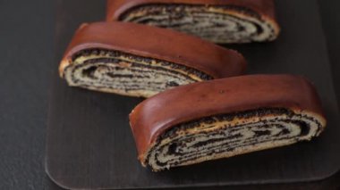 Koyu beton arka planda haşhaş tohumlu ev yapımı tatlı rulo.