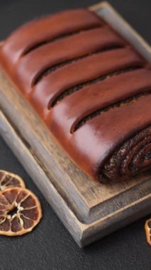 Koyu beton arka planda haşhaş tohumlu ev yapımı tatlı rulo.