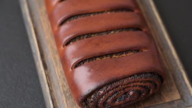 Koyu beton arka planda haşhaş tohumlu ev yapımı tatlı rulo.