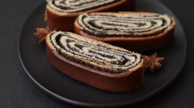 Koyu beton arka planda haşhaş tohumlu ev yapımı tatlı rulo.