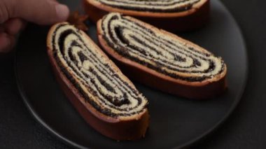 Koyu beton arka planda haşhaş tohumlu ev yapımı tatlı rulo.