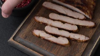 Izgarada pişirilmiş leziz domuz eti. Koyu beton arka planda tuz, baharat ve otlarla birlikte.